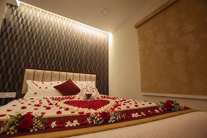 Room at SRK Clasic decorated with a rose-petal heart, towel swans and fresh flowers
