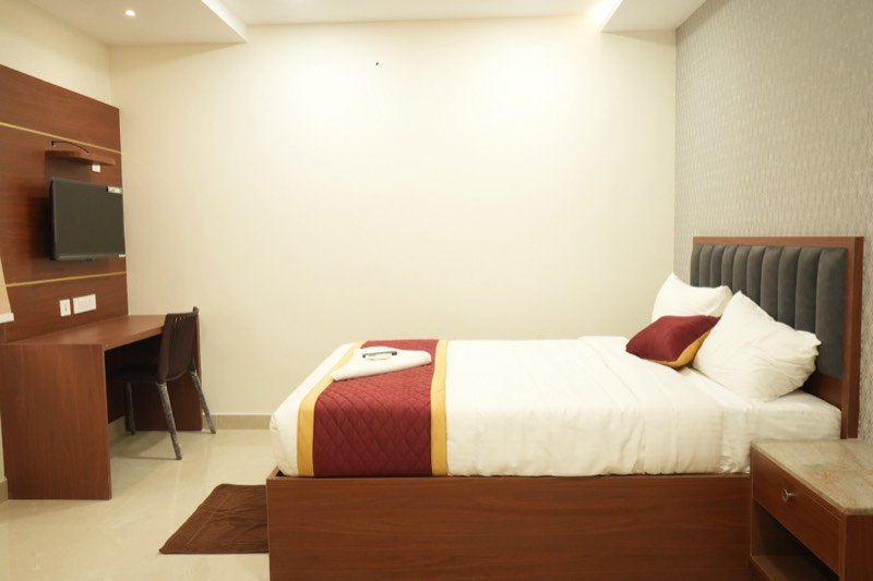 Executive Deluxe room at SRK Clasic with double bed, work desk and television